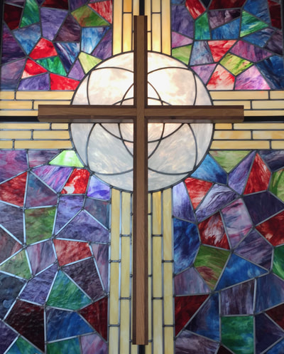 Picture of the stain glass and cross at the front of the sanctuary 